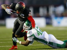 Saskatchewan Roughriders Derrick Moncrief tackles Calgary Stampeders ballcarrier Markeith Ambles at McMahon Stadium in Calgary on Oct. 20, 2018.