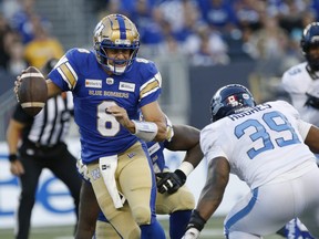 Winnipeg Blue Bombers quarterback Zach Collaros (8) scrambles away from Toronto Argonauts' Charleston Hughes (39) during the first half of CFL action in Winnipeg Friday, August 13, 2021.