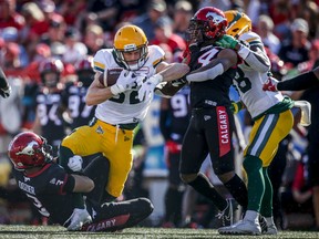 Edmonton Elks slotback Greg Ellingson, centre, catches a pass as Calgary Stampeders close in on him in Calgary on Monday, Sept. 6, 2021.