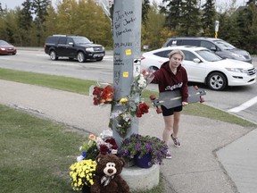 A memorial with flowers has been erected at the intersection of Jennifer Heil Way and Spruce Ridge Road on Sunday, Sept. 26, 2021 in Spruce Grove, AB, after a 25-year-old man was killed in a hit-and-run on Friday.