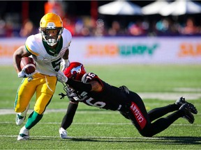 Edmonton Elks running back Terry Williams escapes the tackle Royce Metchie of the Calgary Stampeders in Calgary on Monday, Sept. 6, 2021.