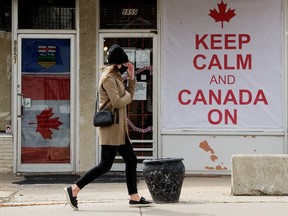 A pedestrian, wearing a mask to protect against COVID-19, makes their way past the O'Canada Gear store, 9859 76 Avenue, in Edmonton Thursday April 22, 2021. Photo by David Bloom