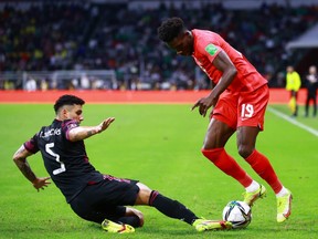 Jorge Sanchez of Mexico battles for possesion with Alphonso Davies of Canada during the match between Mexico and Canada as part of the Concacaf 2022 FIFA World Cup Qualifier at Azteca Stadium on October 07, 2021 in Mexico City, Mexico.