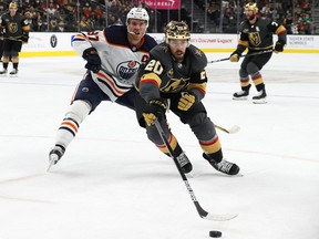 Chandler Stephenson (20) of the Vegas Golden Knights skates with the puck against Connor McDavid (97) of the Edmonton Oilers at T-Mobile Arena on Oct. 22, 2021, in Las Vegas.