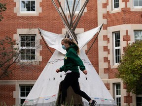 A student walks past a teepee outside of Pembina Hall at the University of Alberta in a COVID-19 mask as they walk through the campus in Edmonton, on Thursday, Sept. 16, 2021. Classes have been canceled as the provincial government declared a state of emergency due to the COVID-19 pandemic. Photo by Ian Kucerak