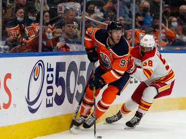 Edmonton Oilers’ Connor McDavid (97) battles Calgary Flames’ Oliver Kylington (58) at Rogers Place in Edmonton on Monday, Oct. 4, 2021.