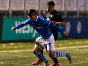 FC Edmonton’s Paris Donald Gee (2) and Pacific FC’s Terran Campbell (14) battle during first half Canadian Premier League action at Clarke Stadium in Edmonton, on Wednesday, Oct. 6, 2021.