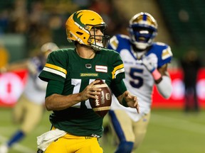 Edmonton Elks quarterback Taylor Cornelius (15) runs from Winnipeg Blue Bombers defensive end Willie Jefferson (5) at Commonwealth Stadium in Edmonton on Friday, Oct. 15, 2021.