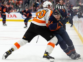 Edmonton Oilers’ Warren Foegele (37) battles Philadelphia Flyers’ Rasmus Ristolainen (70) during third period NHL action at Rogers Place in Edmonton, on Wednesday, Oct. 27, 2021.