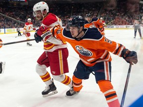 Edmonton Oilers' Kailer Yamamoto (56) battles Calgary Flames' Johnny Gaudreau (13) during second period preseason NHL action at Rogers Place in Edmonton, on Monday, Oct. 4, 2021.