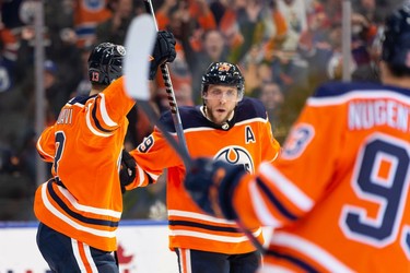 Edmonton Oilers' Leon Draisaitl (29) celebrates scoring on Calgary Flames' goaltender Jacob Markstrom (25) with Jesse Puljujarvi (13) and Ryan Nugent-Hopkins (93) during third period preseason NHL action at Rogers Place in Edmonton, on Monday, Oct. 4, 2021.