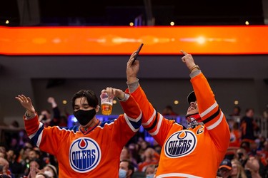 Edmonton Oilers fans cheer Connor McDavid's goal on Calgary Flames' goaltender Jacob Markstrom (25) during third period preseason NHL action at Rogers Place in Edmonton, on Monday, Oct. 4, 2021.