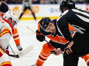 Edmonton Oilers' Leon Draisaitl (29) faces off against Calgary Flames' Elias Lindholm (28) during third period preseason NHL action at Rogers Place in Edmonton, on Monday, Oct. 4, 2021.