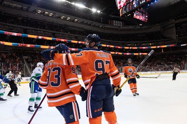 Edmonton Oilers' Connor McDavid (97) celebrates a goal with teammates on Vancouver Canucks' Jaroslav Halak (41) during the first period of preseason NHL action at Rogers Place in Edmonton, on Thursday, Oct. 7, 2021. Photo by Ian Kucerak