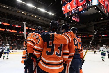 Edmonton Oilers' Connor McDavid (97) celebrates a goal with teammates on Vancouver Canucks' Jaroslav Halak (41) during the first period of preseason NHL action at Rogers Place in Edmonton, on Thursday, Oct. 7, 2021.