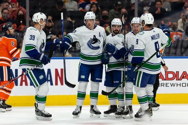 Vancouver Canucks Nic Petan (7) celebrates a goal on Edmonton Oilers' goaltender Mike Smith (41) with teammates during the second period of preseason NHL action at Rogers Place in Edmonton, on Thursday, Oct. 7, 2021.