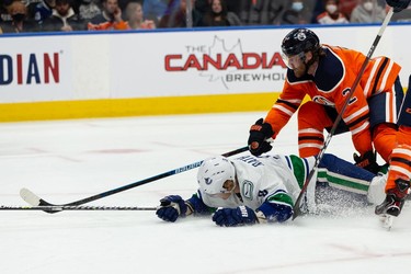 Edmonton Oilers' Duncan Keith (2) draws a penalty with a hit on Vancouver Canucks' Jack Rathbone (3) during the second period of preseason NHL action at Rogers Place in Edmonton, on Thursday, Oct. 7, 2021.