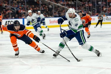 Edmonton Oilers' Cody Ceci (5) battles Vancouver Canucks' Jason Dickinson (18) during the second period of preseason NHL action at Rogers Place in Edmonton, on Thursday, Oct. 7, 2021. Photo by Ian Kucerak