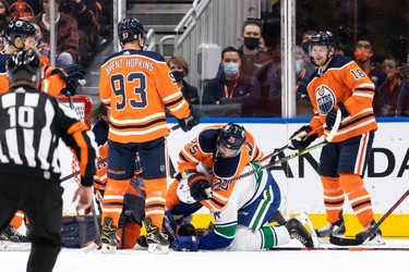 Edmonton Oilers' Darnell Nurse (25) battles Vancouver Canucks' Zack MacEwen (71) during the third period of preseason NHL action at Rogers Place in Edmonton, on Thursday, Oct. 7, 2021.