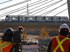 Media film a LRT train crossing the Tawatinâ Bridge over the North Saskatchewan River for the first time during testing phases on Tuesday, Oct. 12, 2021.