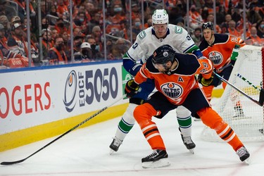 Edmonton Oilers' Leon Draisaitl (29) battles Vancouver Canucks' Tyler Myers (57) during first period NHL action at Rogers Place in Edmonton, on Wednesday, Oct. 13, 2021.