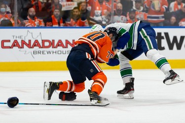 Edmonton Oilers' Colton Sceviour (70) fights Vancouver Canucks' Tyler Myers (57) during second period NHL action at Rogers Place in Edmonton, on Wednesday, Oct. 13, 2021.
