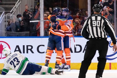 Edmonton Oilers' Zach Hyman (18) celebrates a goal with teammates on Vancouver Canucks' goaltender Thatcher Demko (35) during second period NHL action at Rogers Place in Edmonton, on Wednesday, Oct. 13, 2021.