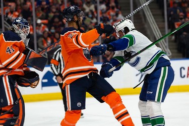 Edmonton Oilers' Darnell Nurse (25) battles Vancouver Canucks' J.T. Miller (9) during second period NHL action at Rogers Place in Edmonton, on Wednesday, Oct. 13, 2021.