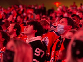 Hockey fans sing the national anthem as the Edmonton Oilers play the Vancouver Canucks during NHL action at Rogers Place in Edmonton on Wednesday, Oct. 13, 2021.