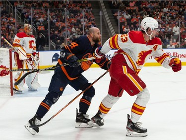 Edmonton Oilers' Zack Kassian (44) battles Calgary Flames Sean Monahan (23) during first period NHL action at Rogers Place in Edmonton, on Saturday, Oct. 16, 2021.