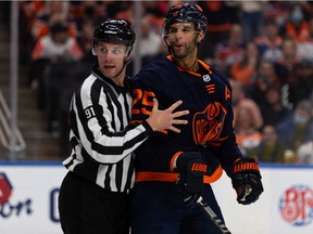 Edmonton Oilers' Darnell Nurse (25) battles Calgary Flames Andrew Mangiapane (88) at Rogers Place in Edmonton on Oct. 16, 2021.