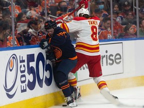 Edmonton Oilers' Kailer Yamamoto (56) battles Calgary Flames Christopher Tanev (8) during first period NHL action at Rogers Place in Edmonton, on Saturday, Oct. 16, 2021.