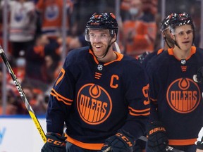 Edmonton Oilers' Connor McDavid (97) celebrates a goal on Calgary Flames goaltender Jacob Markstrom (25) with teammates during second period NHL action at Rogers Place in Edmonton, on Saturday, Oct. 16, 2021.