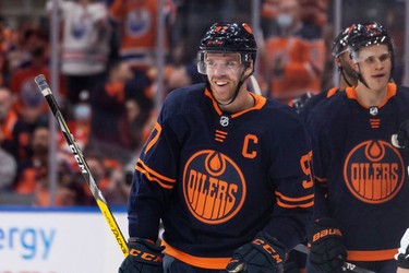 Edmonton Oilers' Connor McDavid (97) celebrates a goal on Calgary Flames goaltender Jacob Markstrom (25) with teammates during second period NHL action at Rogers Place in Edmonton, on Saturday, Oct. 16, 2021.