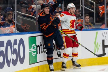 Edmonton Oilers' Tyson Barrie (22) battles Calgary Flames Andrew Mangiapane (88) during second period NHL action at Rogers Place in Edmonton, on Saturday, Oct. 16, 2021.