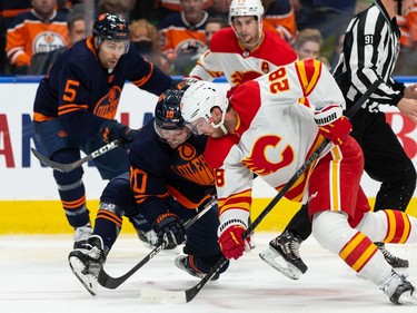 Edmonton Oilers' Derek Ryan (10) battles Calgary Flames Elias Lindholm (28) during second period NHL action at Rogers Place in Edmonton, on Saturday, Oct. 16, 2021.
