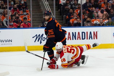 Edmonton Oilers' Darnell Nurse (25) battles Calgary Flames' Oliver Kylington (58) during first period NHL action at Rogers Place in Edmonton, on Saturday, Oct. 16, 2021.