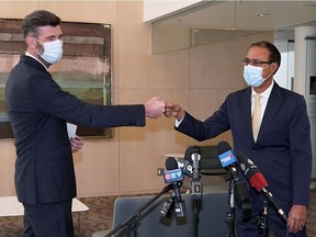 Edmonton Mayor Don Iveson, left, greets mayor-elect Amarjeet Sohi at city hall on Tuesday, Oct. 19, 2021.