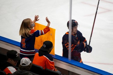 An Edmonton Oilers fan cheers as Kailer Yamamoto (56) warms up during warmup against the Philadelphia Flyers at Rogers Place in Edmonton, on Wednesday, Oct. 27, 2021.