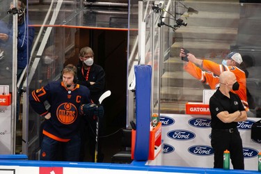 An Edmonton Oilers fan takes a photo as Connor McDavid (97) does an interview during warmup before a NHL game against the Philadelphia Flyers at Rogers Place in Edmonton, on Wednesday, Oct. 27, 2021.