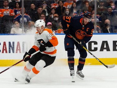 Edmonton Oilers' Connor McDavid (97) battles Philadelphia Flyers' Nicolas Aube-Kubel (62) during first period NHL action at Rogers Place in Edmonton, on Wednesday, Oct. 27, 2021.