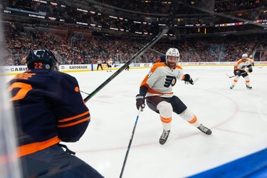 Edmonton Oilers' Tyson Barrie (22) battles Philadelphia Flyers' Sean Couturier (14) during second period NHL action at Rogers Place in Edmonton, on Wednesday, Oct. 27, 2021.