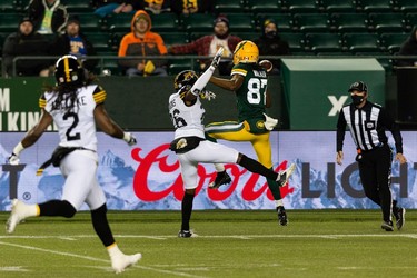 Edmonton Elks' Derel Walker (87) misses a catch as  Hamilton Tiger-Cats' Cariel Brooks (26) reaches for a block during first half CFL action at Commonwealth Stadium in Edmonton, on Friday, Oct. 29, 2021.