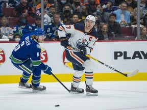 Vancouver Canucks forward Brock Boeser (6) moves the puck past Edmonton Oilers forward Connor McDavid (97) in the first period at Rogers Arena on Oct. 30, 2021