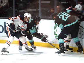 The Edmonton Oilers' Ryan McLeod, left, and the Seattle Kraken's Calle Jarnkrok (19) move in as Kraken's Carson Soucy (28) and Oilers' Colton Sceviour battle for the puck on Oct. 1, 2021, in Everett, Wash.