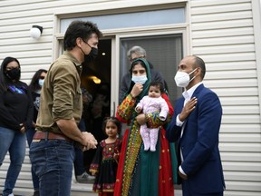 Prime Minister Justin Trudeau greets Obaidullah Rahimi, right, his wife Arezoo, and daughters Hawa, 2 months, and Ayat, 3, in Ottawa, on Saturday, Oct. 9, 2021. Obaidullah Rahimi worked at the Canadian Embassy in Afghanistan; his family is one of 22 resettled Afghan families in the Ottawa area. THE CANADIAN PRESS/