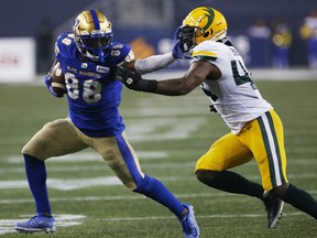 The Winnipeg Blue Bombers' Rasheed Bailey (88) makes the first down against Edmonton Elks linebacker Keishawn Bierria (44) in Winnipeg on Friday, Oct. 8, 2021.