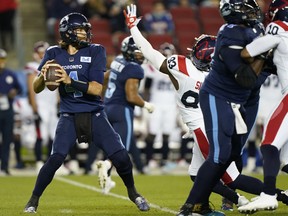 Toronto Argonauts quarterback McLeod Bethel-Thompson (4) looks to pass as he is pressured by Montreal Alouettes defensive lineman Antonio Simmons (93) at BMO Field in Toronto on Sept. 24, 2021.