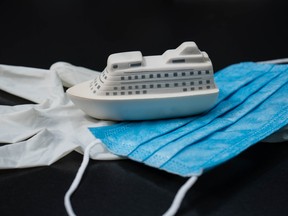 A cruise ship model with gloves and face mask.