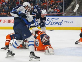 Edmonton Oilers goaltender Mikko Koskinen (19) makes a save on Winnipeg Jets forward Jansen Harkins (12) at Rogers Place on Saturday, Oct. 2, 2021.